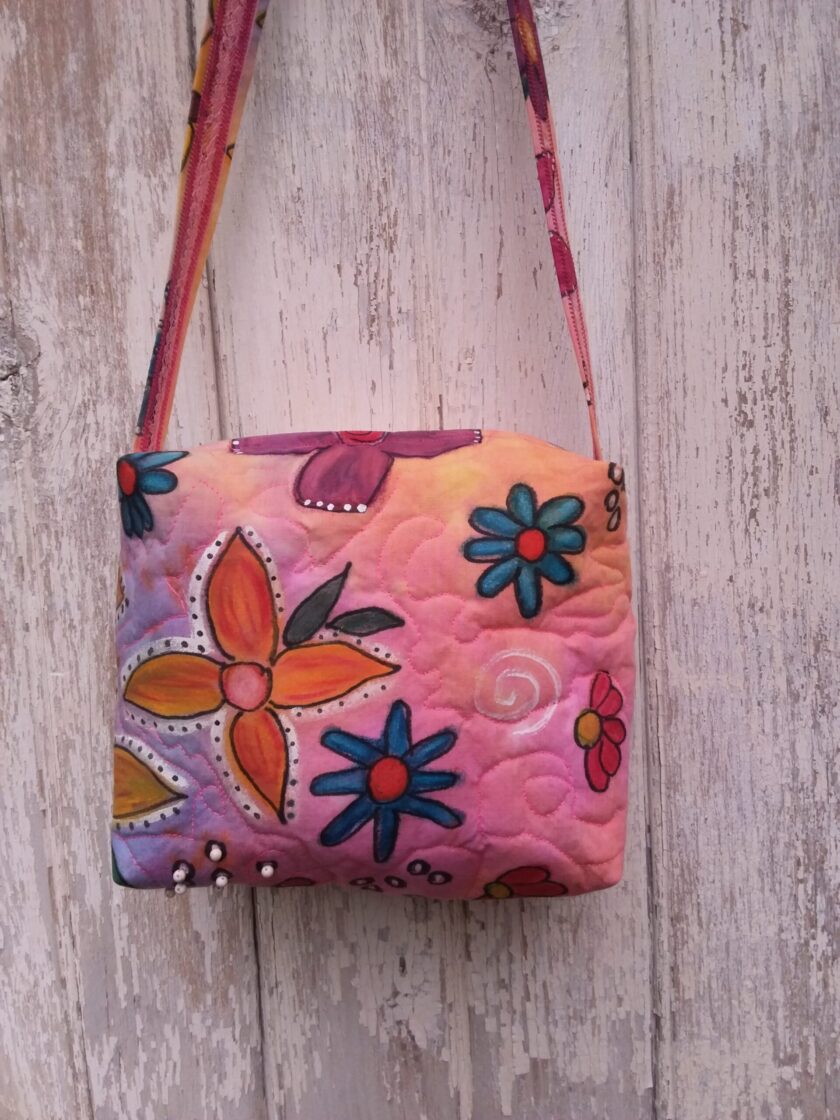 Bright hand painted flowers in purple, yellow and blue on a hand dyed bag with beaded accents