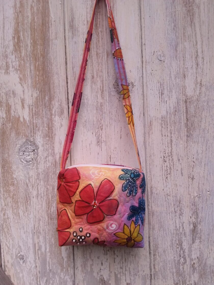 Unique hand dyed and painted bag with bold red, blue and yellow flowers.