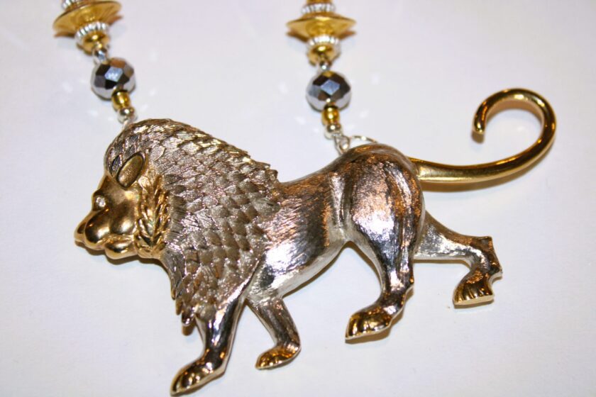 A necklace with a silver and gold lion pendant .